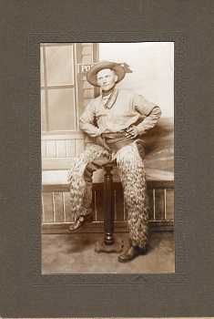 COWBOY IN WOOLY CHAPS WITH CARTRIDGE BELT & HOLSTER.